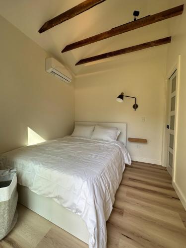 a bedroom with a white bed and wooden floors at Modern cabin retreat in Catskill