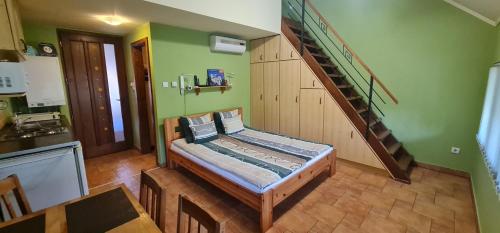 a room with a staircase and a kitchen with a table at Maja Apartman in Gyula