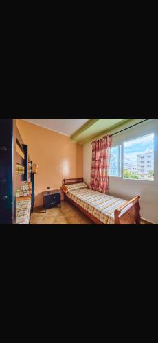a bedroom with a bed and a window at Residence oum kaltoum in Oued Laou