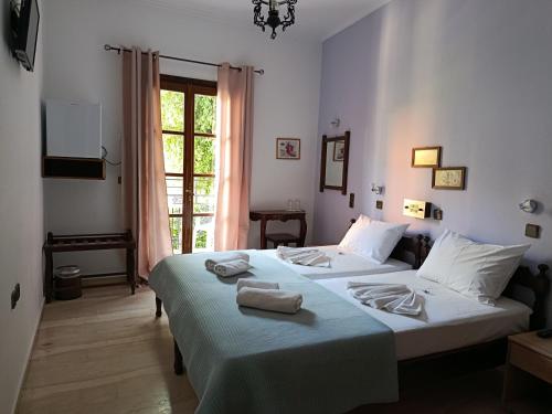 a bedroom with two beds with towels on them at Pegasus Hotel in Pythagoreio
