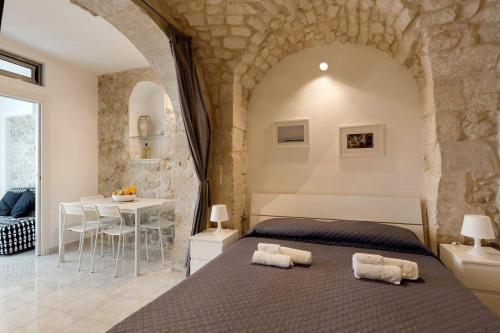 a bedroom with a large bed and a table at Casa Nerina in centro Scicli in Scicli