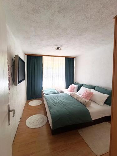 a bedroom with a large bed and a television at Apartman Soldat in Šipovo