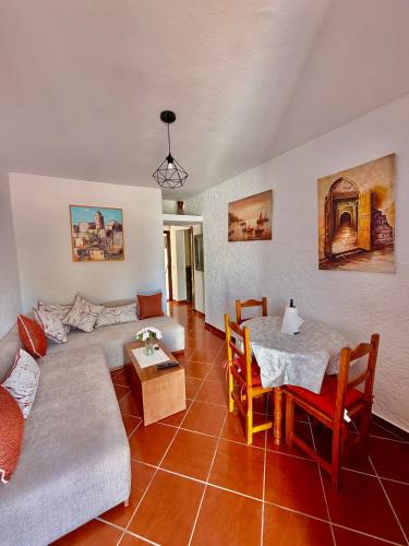 a living room with a couch and a table at Résidence Mdiq marsa - maison de vacances in M'diq