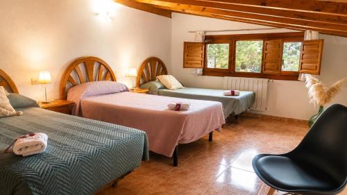 a hotel room with two beds and a chair at Pensión San Cristóbal by Bossh! Hotels in Cuenca