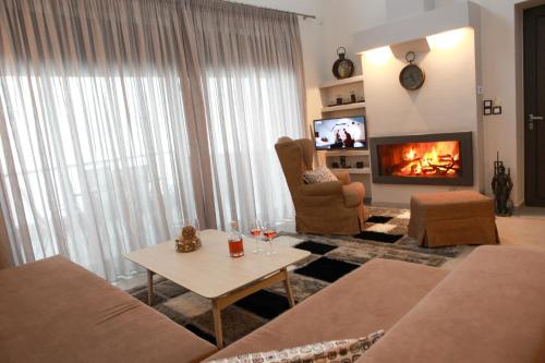 a living room with a couch and a fireplace at Petra Thea in Kalamata