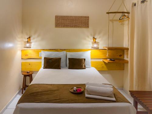 a bedroom with a large white bed with two pillows at Pousada Do Porto in Barreirinhas