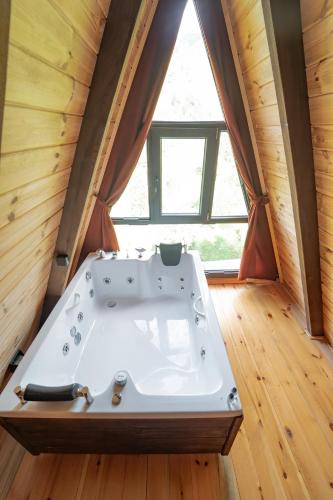 a bath tub in a tiny house with a window at Danzi camping tiny house in Kise