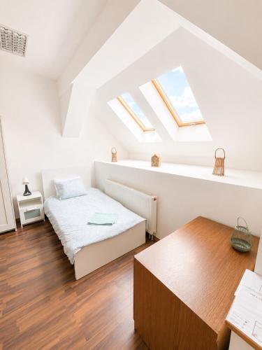 a attic bedroom with a bed and a table at Konvoj szálló in Budapest