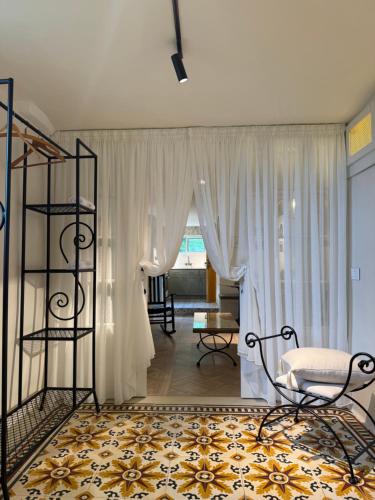 a living room with white curtains and a table and chairs at A Lómbre in Ḩarīq al Kufūr