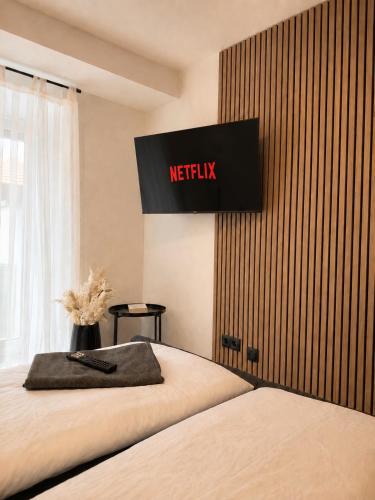 a bedroom with a bed with a television on the wall at Modernes Appartement mit Balkon & Parkplatz - Waldshut-Tiengen in Waldshut-Tiengen