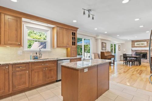 a kitchen with wooden cabinets and a living room at Spacious Edgewater Home Deck & Sleeps 10 in Edgewater