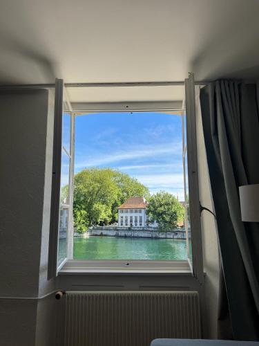 a window in a room with a view of a building at Aarebar Rooms in Solothurn