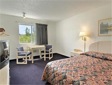 Habitación de hotel con cama y escritorio en Americas Stay Inn-Leavenworth, en Leavenworth