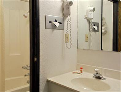 bagno con lavandino e telefono appeso al muro di Americas Stay Inn-Leavenworth a Leavenworth