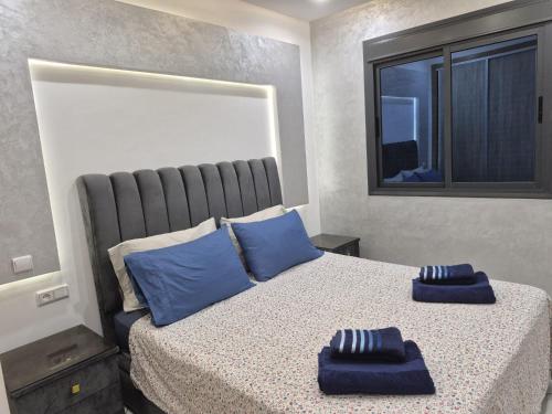 a bedroom with a bed with blue pillows on it at Beachfront First floor mekad in Oued Laou