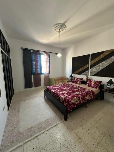 a bedroom with a large bed and a large window at Appartement henda 01 in Sousse