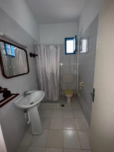 a white bathroom with a sink and a toilet at Appartement henda 01 in Sousse