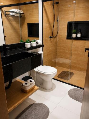 a bathroom with a toilet and a glass shower at Studio Chico 02 in Espirito Santo Do Pinhal