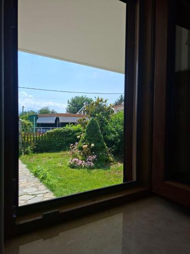 a view of a garden through a window at IVY Traditional House in Amigdhaleón
