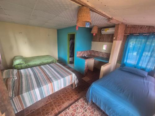 a bedroom with two beds and a table in it at Cabañas T Estefany in Bocas Town