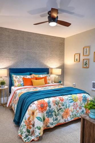 a bedroom with a blue bed with colorful pillows at Seaside Saloon Hot Tub Getaway in Sequim