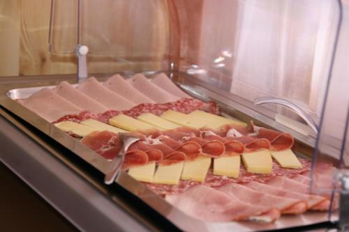 a display case with cheese and meat and cheese sticks at Hotel Glärnisch Hof in Horgen