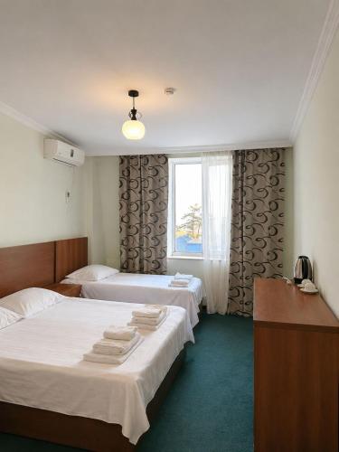 a hotel room with two beds and a window at Renesans Hotel Kobuleti in Kobuleti