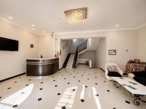 a large living room with a staircase and a couch at Renesans Hotel Kobuleti in Kobuleti