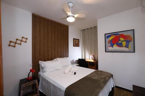 a hotel room with a bed and a ceiling fan at Confortável 1 Quarto Ar Wi-fi Garagem in Vitória