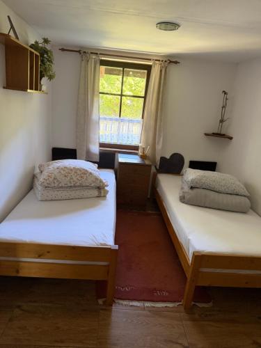 two beds in a room with a window at Dom nad rzeką in Neple