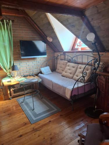 a bedroom with a bed and a tv in a attic at Agroturystyka Kalina Wielka in Kalina Wielka