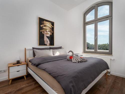 a bedroom with a large bed and a window at "Sonnenstübchen" Apartment mit eigenem Parkplatz und WiFi in Magdeburg