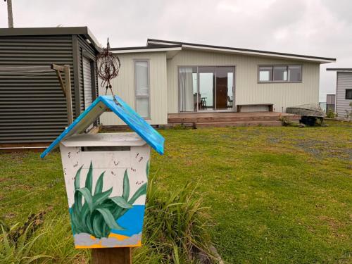 a house with a sign in front of it at Whatuwhiwhi View in Karikari Peninsula