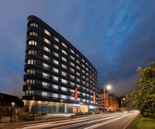 wysoki budynek na miejskiej ulicy nocą w obiekcie VOU Suites by Avia Suites w mieście Bogota