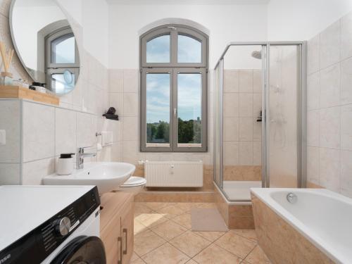 a white bathroom with a sink and a shower at "Sonnenstübchen" Apartment mit eigenem Parkplatz und WiFi in Magdeburg