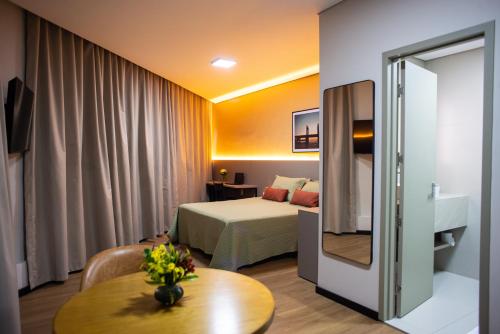 a hotel room with a bed and a table at Petrolina Palace Hotel in Petrolina
