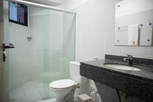 a bathroom with a toilet and a shower and a sink at Petrolina Palace Hotel in Petrolina
