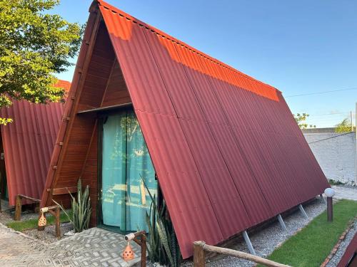 a red roofed house with a green door at Pousada Villa Al Mare in Luis Correia