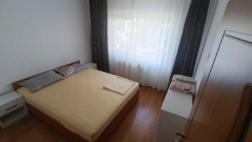 a small bedroom with a bed and a window at Dana in Piteşti