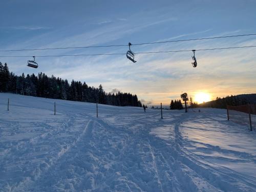 a ski lift with people on it in the snow at Chalet Les Jouves in Prémanon