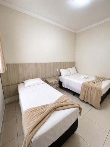 a hotel room with two beds in a room at Glória Hotel in Olímpia