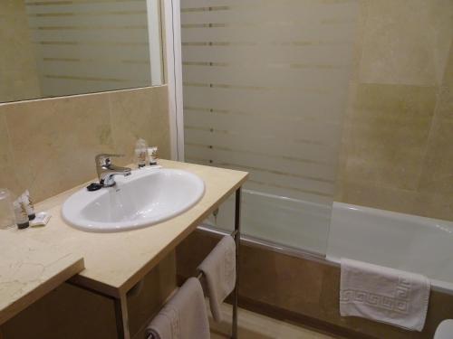 a bathroom with a sink and a bath tub at Peregrina Hotel in Sanxenxo