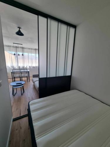 a bedroom with a bed and a dining room at Palma 2 in Port-la-Nouvelle