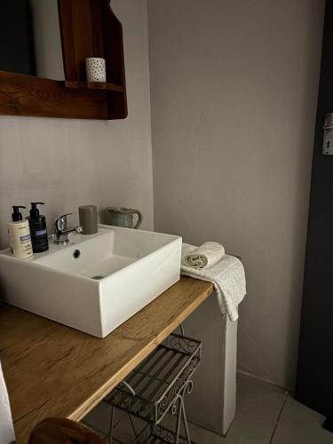 a bathroom with a white sink on a wooden counter at Dune Ridge Cottage in Port Alfred