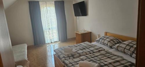 a bedroom with a bed and a television in it at Penzion Bernardýn in Bořetice