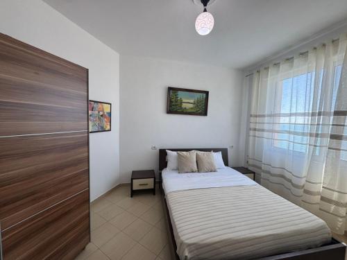 a small bedroom with a bed and a window at SunKissed Apartament in Golem