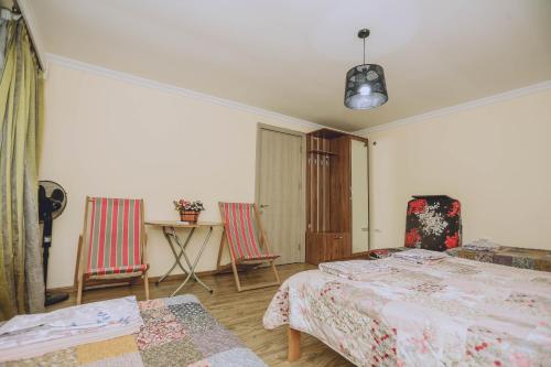 a bedroom with two beds and a table and chairs at Qiwi House in Ureki