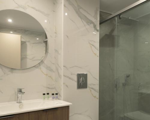 a bathroom with a shower and a sink and a mirror at Amalia Apartments-Suites in Bali
