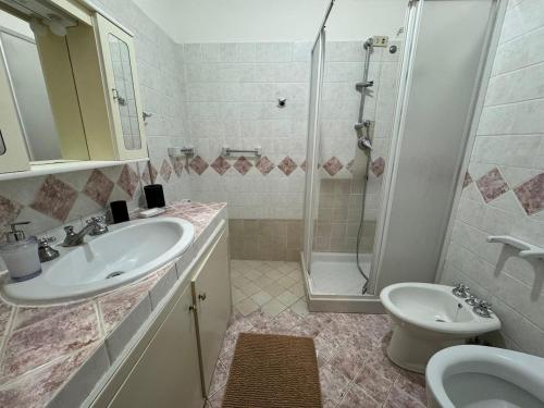 a bathroom with a sink and a shower and a toilet at Casa della nonna in Donisi