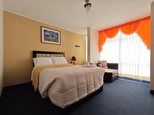 a bedroom with a large bed and a couch at Hostal Amazonas in Chivay